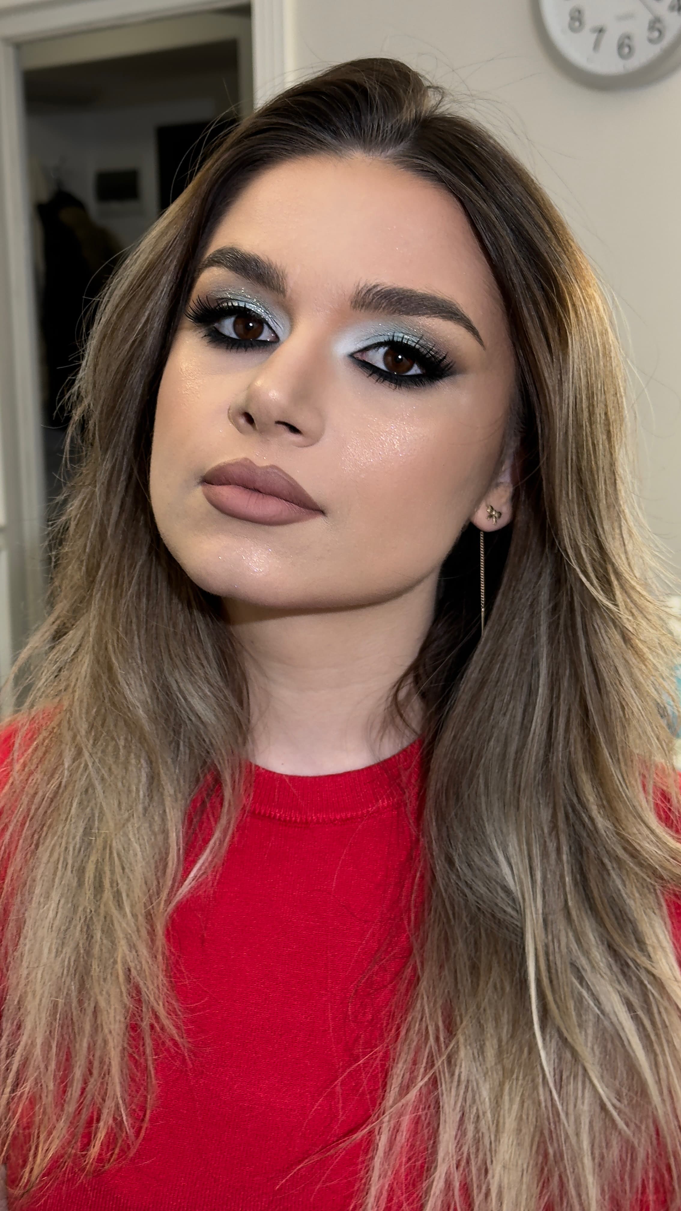 Pleoape argintiu-albăstrui, tuș negru estompat și buze nude-mov. Un look rece și luminos, cu privirea intensă.